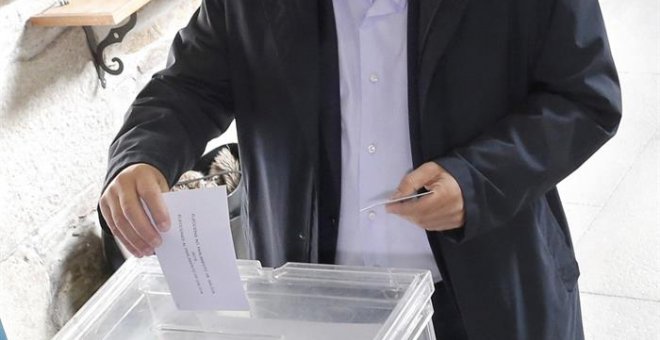Un ciudadano introduce su voto en una urna durante las elecciones gallegas de este domingo.- EFE