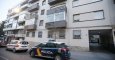 Un coche de Policía y otro de Cruz Roja en la entrada del edificio donde un matrimonio y su hija de 12 años han fallecido en Alicante, al parecer aplastados o asfixiados por cientos de kilos de ropa que acumulaban en su domicilio, después de que se desplo