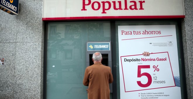 Un hombre utiliza un cajero de una oficina del Banco Popular en Madrid. REUTERS/Andrea Comas