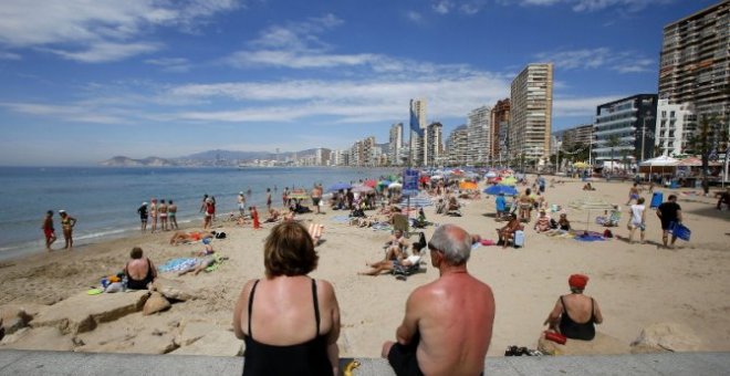 Una pareja de turistas toma el sol en las playas de Benidorm. EFE