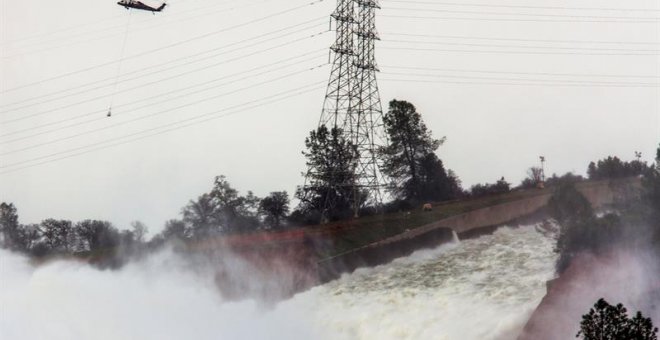 Un helicóptero sobrevuela la presa Oroville y el río Feather con sacos cargados de rocas para aliviar la emergencia ocasionada por la erosión del desagüe en la represa Oroville hoy, lunes 13 de febrero de 2017, en Oroville, California (EE.UU.). Los trabaj