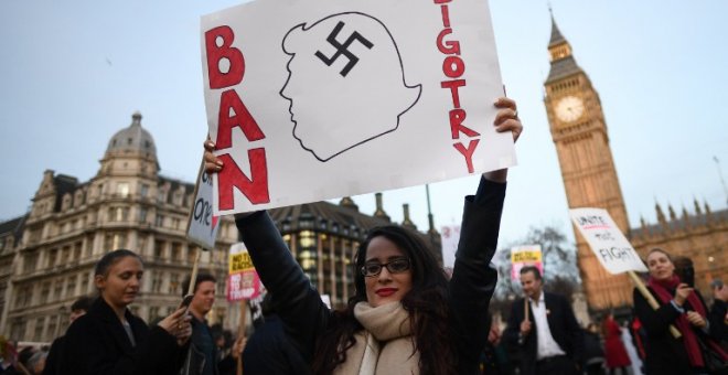 Una manifestante sujeta una pancarta en contra de las políticas antiinmigración de Trump. - AFP