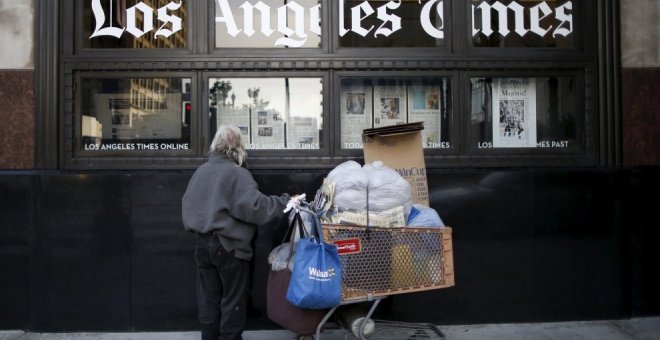 Un hombre lee el 'Los Angeles Times' mientras pasa por el edificio del propio. REUTERS