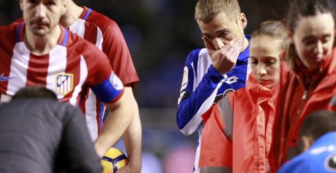El centrocampista del Deportivo de la Coruña, Alejandro Bergantiños (3d), preocupado mientras los servicios médicos atienden al delantero del Atlético de Madrid, Fernando Torres