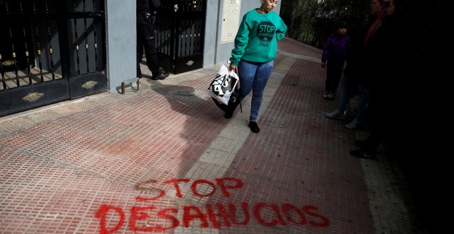 Una mujer abandona su domicilio en la localidad madrileña de Parla después de haber sido sesahuciada. REUTERS/Juan Medina