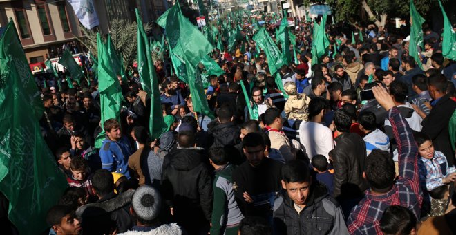 Seguidores del movimiento palestino Hamas con banderas de la organización en la marcha para celebrar el 29 aniversario de su fundación. AFP/Mohammed Abed