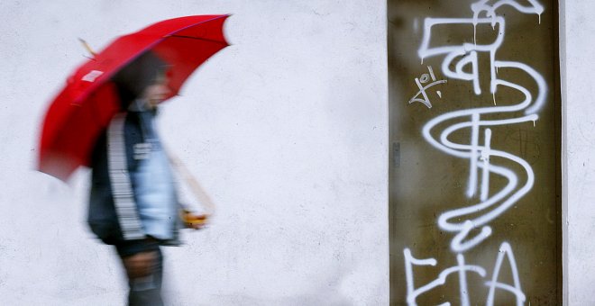 Un joven pasa junto a una pintada de ETA en la ciudad de Guernica. - REUTERS
