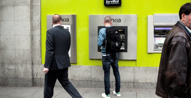 Una persona operando en un cajero automático de Bakia. REUTERS