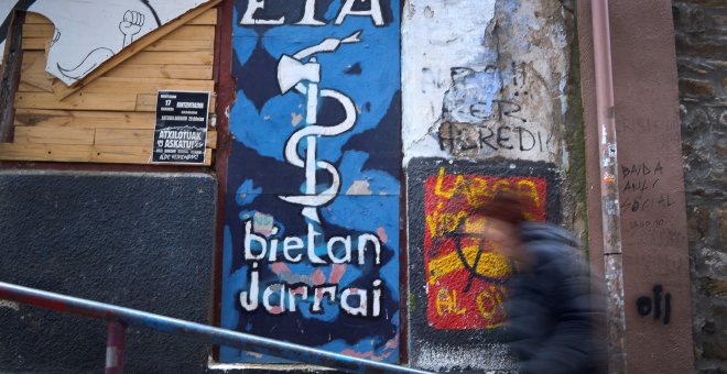 Una personas camina delante de una pintada de ETA en Bermeo, REUTERS/Vincent West