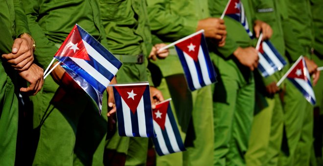 Soldados de la armada cubana sujetan banderas del país caribeño durante el el 60 aniversario de la muerte del líder revolucionario José Antonio Echeverria.REUTERS/Alexandre Meneghini