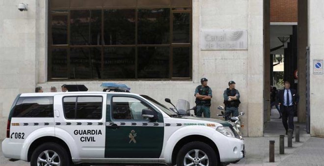 Agentes de la Guardia Civil ante la sede de Canal de Isabel II. | EMILIO NARANJO (EFE)