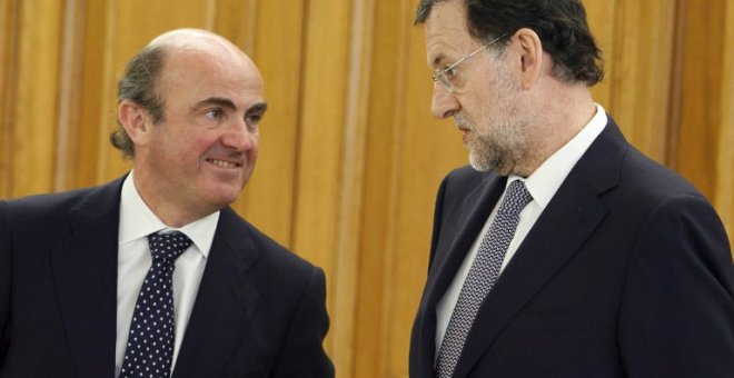 El ministro de Economía, Luis de Guindos, y el presidente del Gobierno, Mariano Rajoy, en una foto de junio de 2011 en el Palacio de la Zarzuela, en la jura del cargo del gobernador del Banco de España Luis Maria Linde.AFP