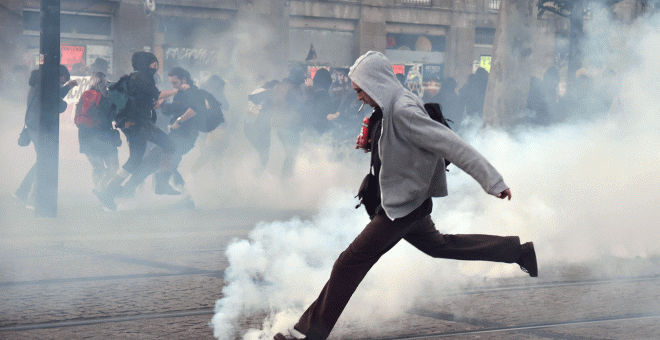 Un manifestante trata de alejar un bote de gas lacrimógeno en Nantes.- AFP
