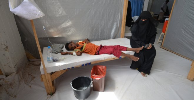 Una mujer se sienta junto a su hijo enfermo de cólera en un hospital de la ciudad de Hodeidah, Yemen.- REUTERS / Abduljabbar Zeyad