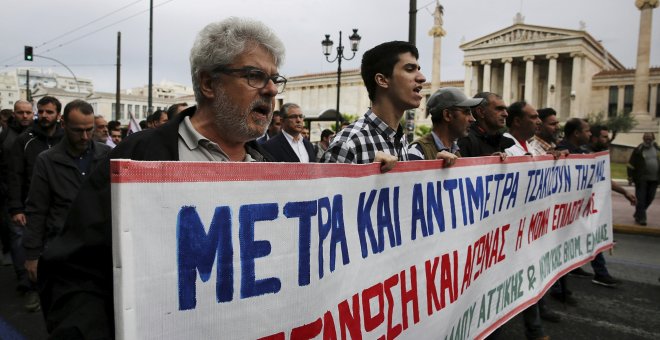 Varios activistas del sindicato comunista PAME corean consignas durante la huelga general de 24 horas contra los últimos recortes pactados con la UE. EFE/Alexandros Vlachos