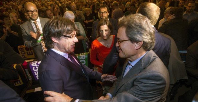 El presidente de la Generalitat Carles Puigdemont, saluda al expresidente Artur Mas en presencia de la presidenta del parlamento catalán, Carme Forcadell. - EFE