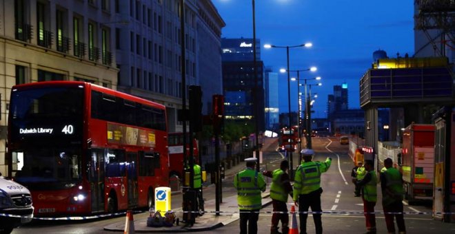 Policías británicos vigilan una calle cortada en el acceso norte del puente de Londres. | NEIL HALL (REUTERS)