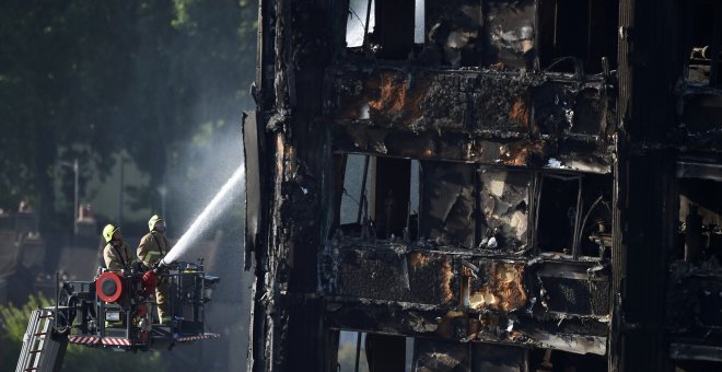 Bomberas echan agua al edificio de 27 plantas incendiado en Londres. - REUTERS