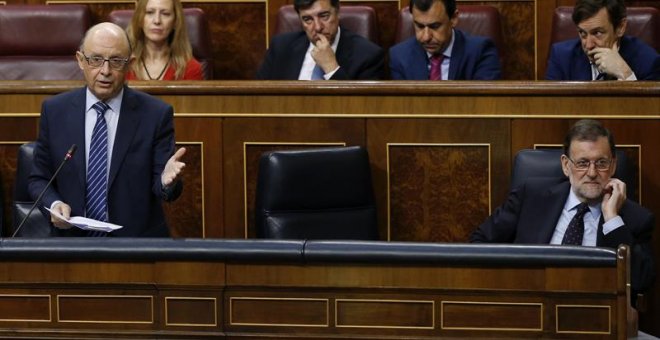 El ministro de Hacienda, Cristóbal Montoro, durante su intervención en la sesión de control al Gobierno hoy el Congreso de los Diputados.A la derecha, el presidente del Gobierno, Mariano Rajoy. EFE/Kiko Huesca