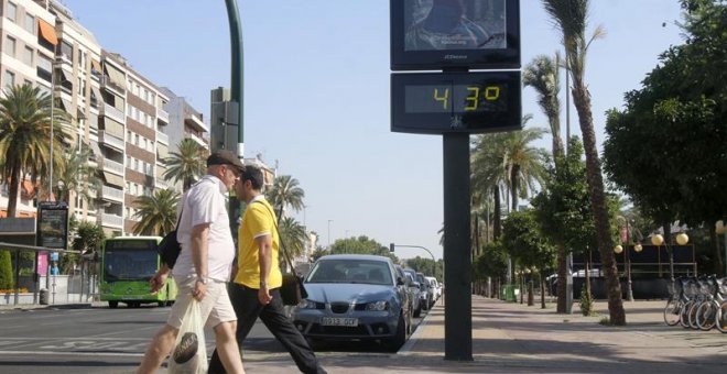 Dos personas pasan junto a un termómetro en Córdoba. - EFE