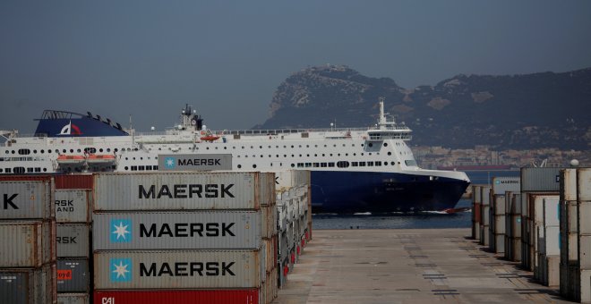 Un ferry pasa junto a los contenedores de la terminal de carga del puerto de Algeciras. REUTERS/Jon Nazca