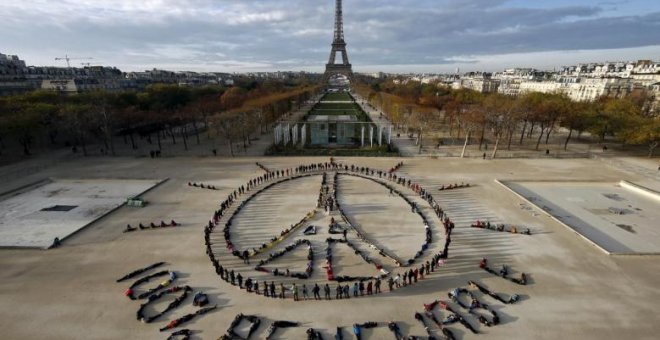 Activistas medioambientales forman el símbolo de la paz cerca de la Torre Eiffel en París, en diciembre de 2015, durante la celebración de la Cumbre del Clima en la capital francesa. REUTERS