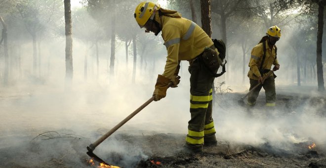 Bomberos trabajan en los alrededores de Mazagón, en Huelva, en el incendio que ha obligado a desalojar a más de 2.000 personas y que continúa acechando el Espacio Natural de Doñana. EFE/Julián Pérez