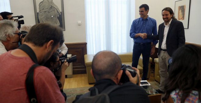 Los secretarios generales del PSOE, Pedro Sánchez, y de Podemos, Pablo Iglesias, se saludan antes de mantener en el Congreso el primer encuentro cara a cara desde hace más de un año para explorar vías de acuerdo entre los dos principales partidos de la op