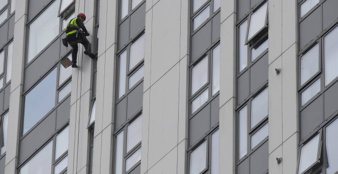 Un desciende por una de las fachadas de la Bray Tower para revisar su revestimiento. REUTERS / Toby Melville