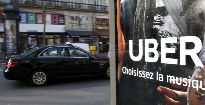 Un taxi parisino pasa por delante de una publicidad de Uber, en una imagen de archivo. REUTERS/Charles Platiau