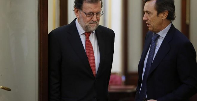 El presidente del Gobierno, Mariano Rajoy (i), conversa con el portavoz del PP en el Congreso, Rafael Hernando, en los pasillos de la Cámara Baja. /EFE