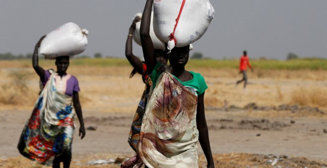 Varias mujeres llevan sacos de alimentos en el pueblo Nimini, en el estado de Unity, al norte de Sudán del Sur.- REUTERS / Siegfried Modola