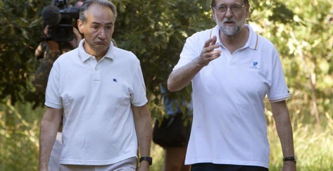 El presidente del Gobierno, Mariano Rajoy (d), acompañado por el presidente de la Autoridad Portuaria de Marín, José Benito Suárez (i), durante su paseo por las orillas del río Umia, en Ribadumia (Pontevedra). EFE/Salvador Sas