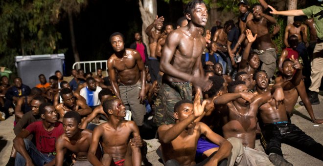 Migrantes en la madrugada de este lunes tras cruzar la frontera del Tarajal entre Marruecos y España. REUTERS