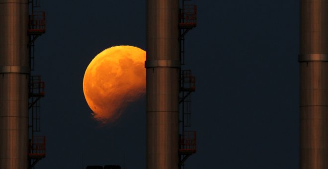 Imagen del eclipse lunar detrás de las chimeneas de una central eléctrica en Delimara (Malta). Darrin Zammit / REUTERS