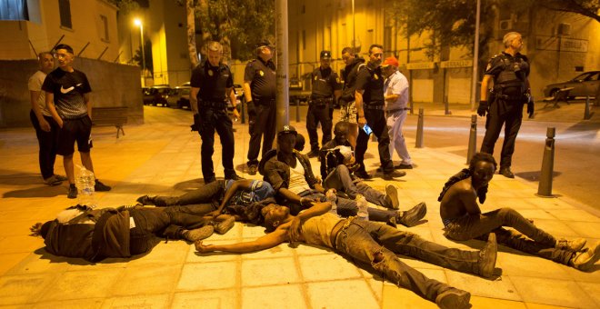 Agentes de Policía junto a un grupo de inmigrantes que logró llegar a Ceuta cruzando a la carrera por el paso de El Tarajal.- REUTERS JESÚS MORON/ ARCHIVO