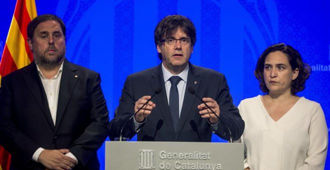 El presidente de la Generalitat, Carles Puigdemont (c), junto a la alcaldesa de Barcelona, Ada Colau (d), y el vicepresidente, Oriol Junqueras (i), hacen una declaración institucional para reprobar el atentado ocurrido esta tarde en Barcelona, un atropell