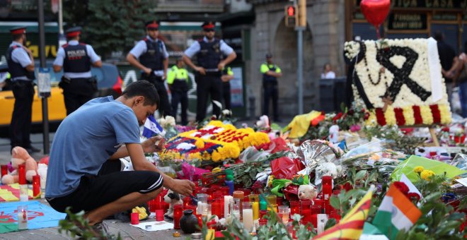 Un hombre enciende una vela en el memorial instalado en Las Ramblas, en memoria de las víctimas del atentado del pasado jueves. REUTERS/Susana Vera