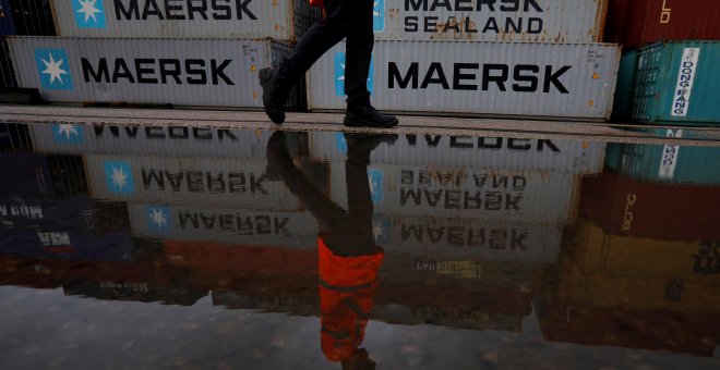 Un hombre pasa junto a varios contenedores de la empresa de transportes danesa Maersk, en Liverpool (Reino UNido). REUTERS/Phil Noble