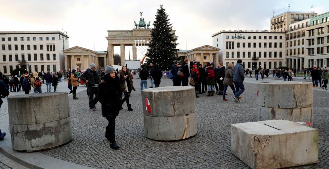 Varios ciudadanos pasean el pasado diciembre junto a las barreras de hormigón colocadas cerca de la Puerta de Brandenburg, en Berlín. REUTERS/Fabrizio Bensch