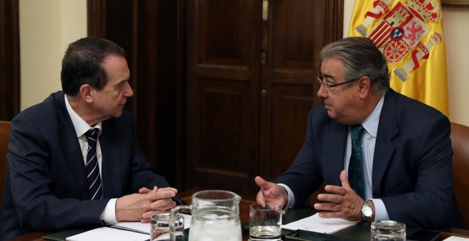 El ministro del Interior, Juan Ignacio Zoido (d), y el presidente de la Federación Española de Municipios y Provincias (FEMP), Abel Caballero (i), durante la reunión que han mantenido en la sede del Ministerio en Madrid, para estudiar vías de cooperación