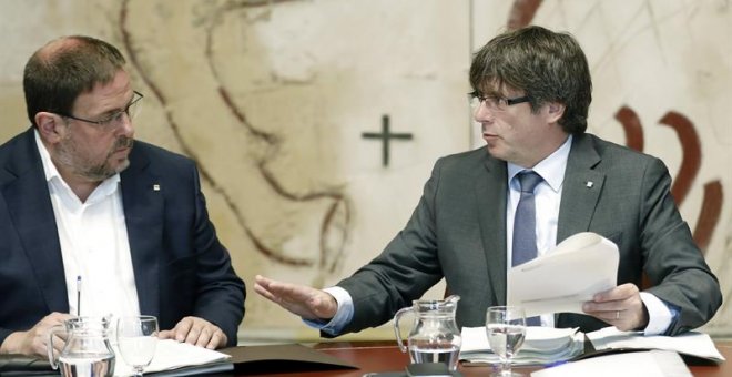 El presidente de la Generalitat, Carles Puigdemont, y el vicepresidente del Govern, Oriol Junqueras (i), hoy durante la reunión semanal del Govern, un día después de presentarse la futura ley de Transitoriedad Jurídica, que marca el camino del pulso seces