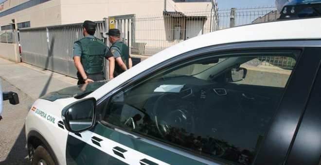 Agentes de la Guardia Civil continúan registrando los vehículos de aquellos empleados que salen de la imprenta ubicada en un polígono industrial de Constantí (Tarragona). / EFE