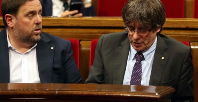 El presidente de la Generalitat, Carles Puigdemont (d) y el vicepresidente del Govern, Oriol Junqueras (i), abandonan hoy el hemiciclo del Parlament de Cataluña a los pocos minutos de iniciarse la sesión a causa de la petición del PPC de suspenderse para