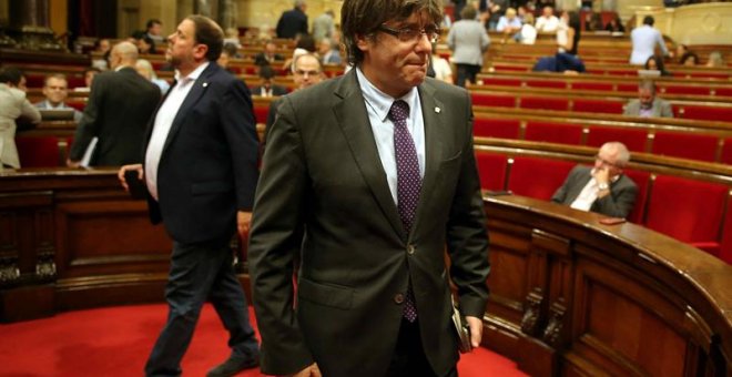 El presidente de la Generalitat, Carles Puigdemont (d) y el vicepresidente del Govern, Oriol Junqueras (i), abandonan hoy el hemiciclo del Parlament de Catalunya. EFE/Toni Albir