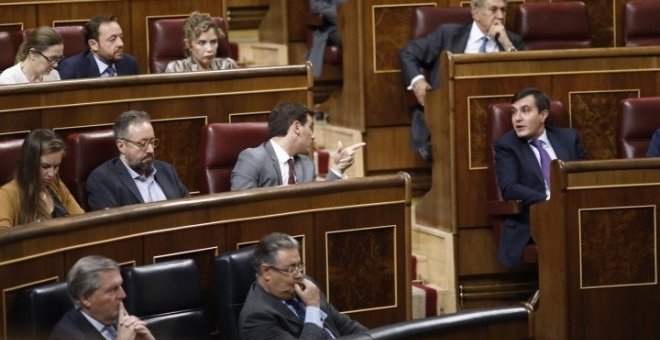 El presidente de Ciudadanos, Albert Rivera, y el diputado del PPy secretario de Estado de Relaciones con las Cortes, José Luis Ayllón, hablan desde sus escaños en el Congreso. E.P.