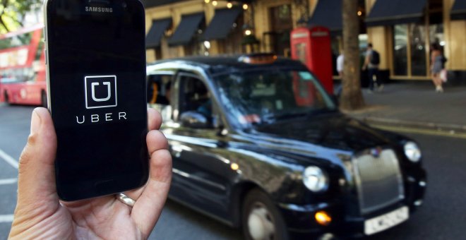 La aplicación de Uber junto a uno de los coches que usa en Londres.