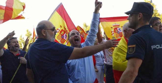 Un grupo de ultras, con banderas de España, increpan a los miembros de Unidos Podemos a las puertas de su asamblea en Zaragoza. /EFE