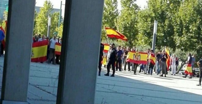 Un grupo de ultras, con banderas de España, increpan a los miembros de Unidos Podemos a las puertas de su asamblea en Zaragoza. /EFE