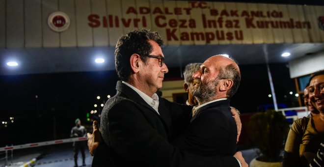 El periodista turco Kadri Gursel (I) abraza al jefe de la delegación de "Cumhuriyet" en Ankara, Erdem Gul (D), tras ser liberado de la prisión de Silivri el 26 de septiembre del 2017, en Estambul. AFP/ Yasin Akgul